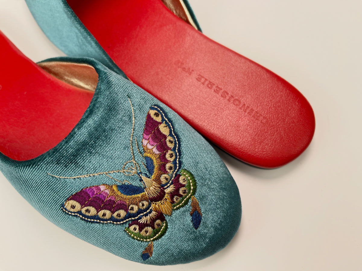 Teal velvet mule slippers with butterfly embroidery; red sole and footbed
