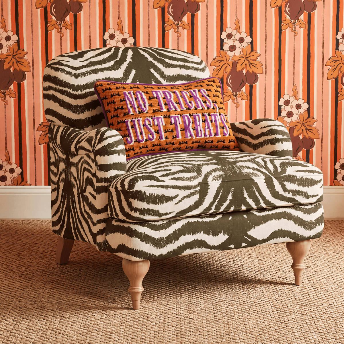 Decorative throw pillow with orange “No Tricks, Just Treats” front and zebra pattern back