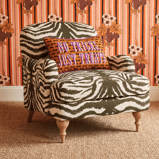 Decorative throw pillow with orange “No Tricks, Just Treats” front and zebra pattern back