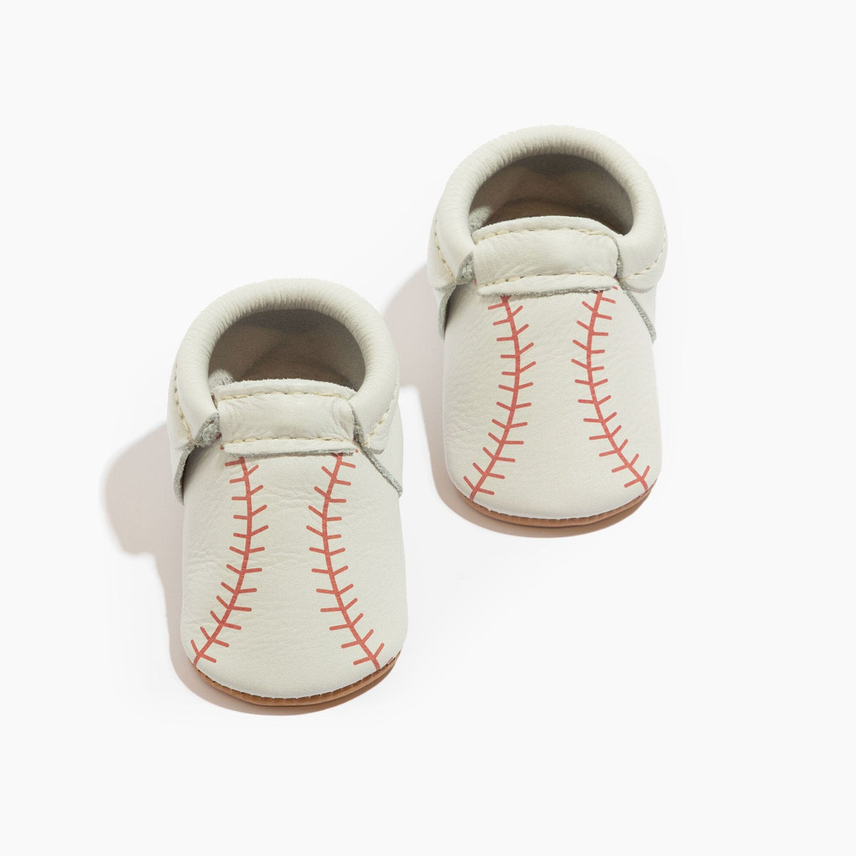White baby baseball shoes with red stitched pattern and soft padded collar