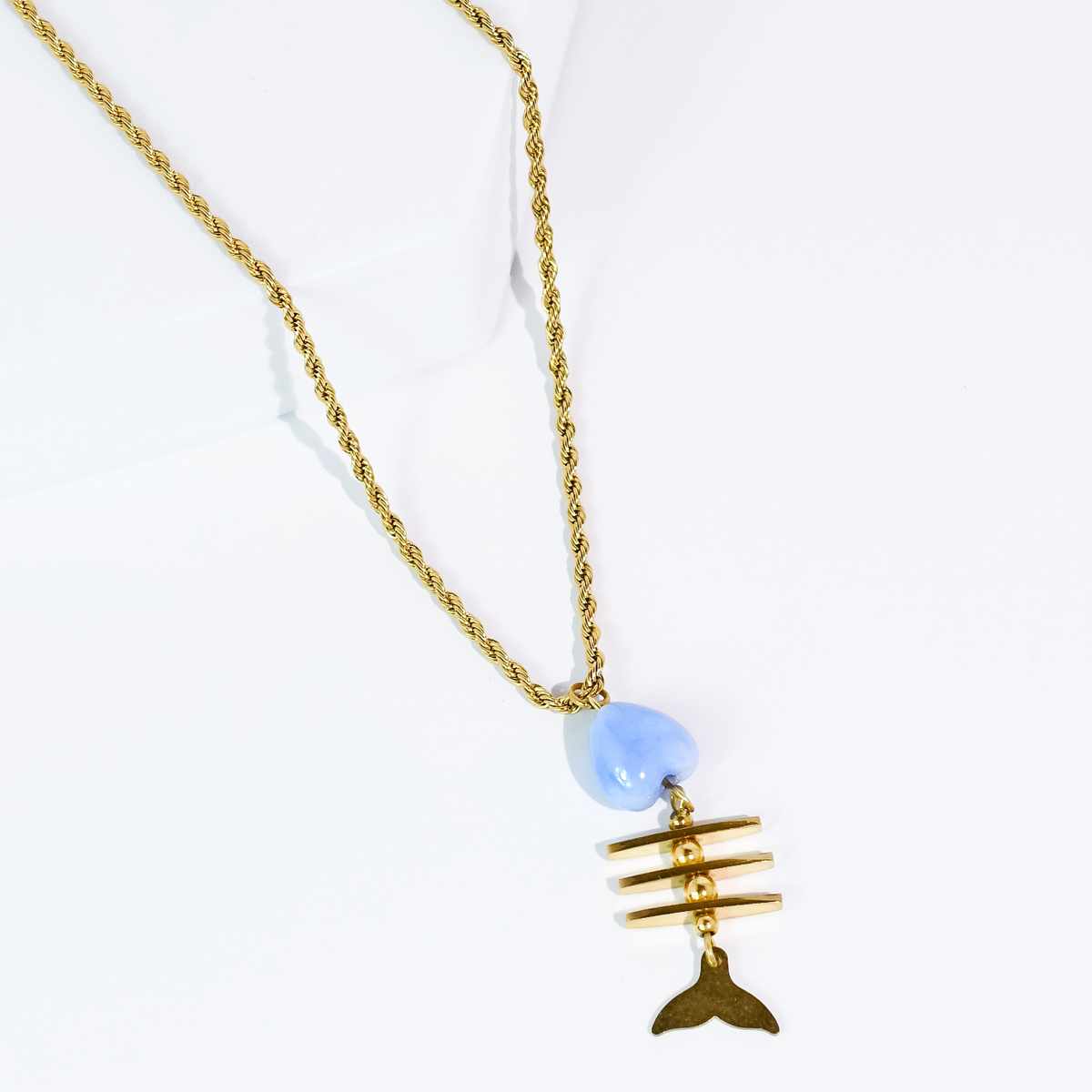 Gold chain necklace with blue bead and fish-shaped pendant