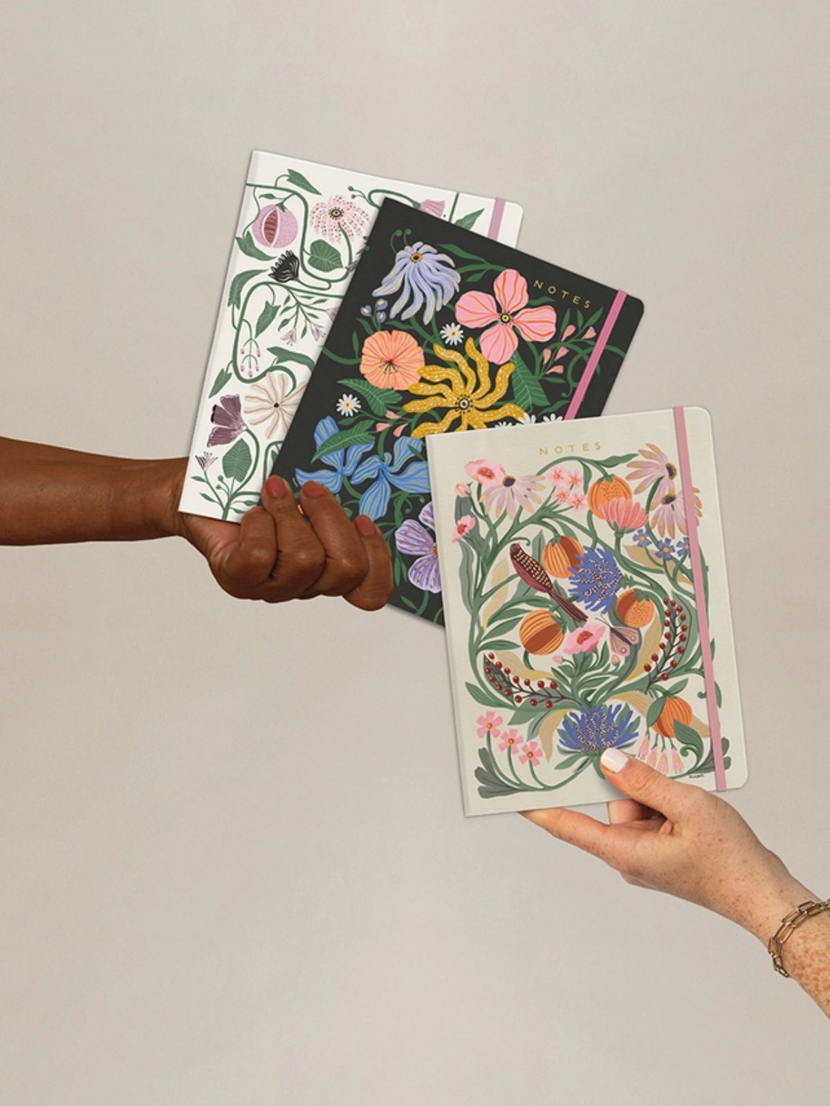 Seam-sewn trio notebook set with botanical illustrated covers in green, pink, and dark tones