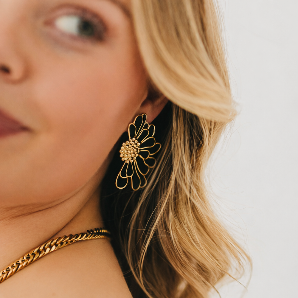 Gold flower stud earrings with black petals and textured center