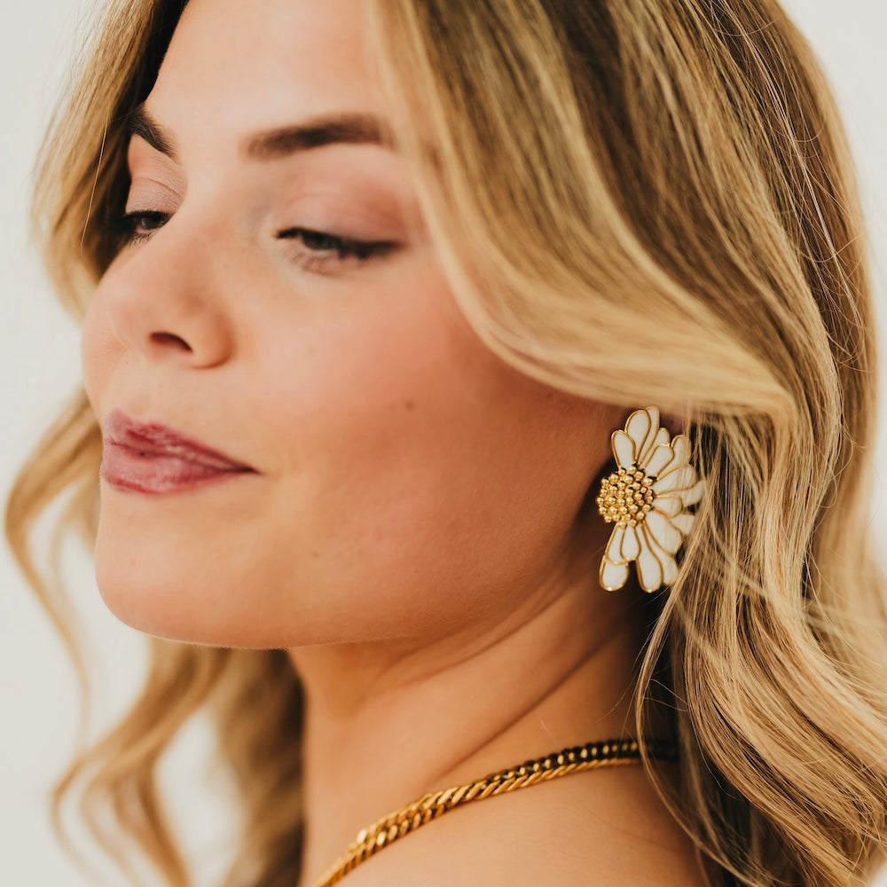 Gold flower stud earrings with white petals and textured center