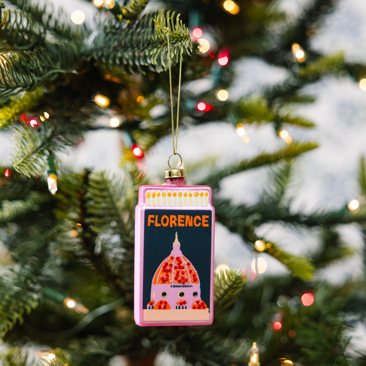 Florence matchbook ornament hanging on a Christmas tree, pink with dome illustration