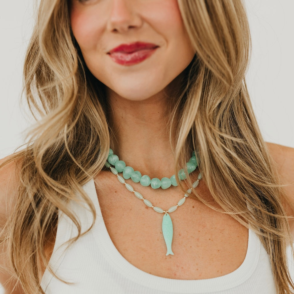 Resin fish charm necklace on model: turquoise tail pendant with bead chain