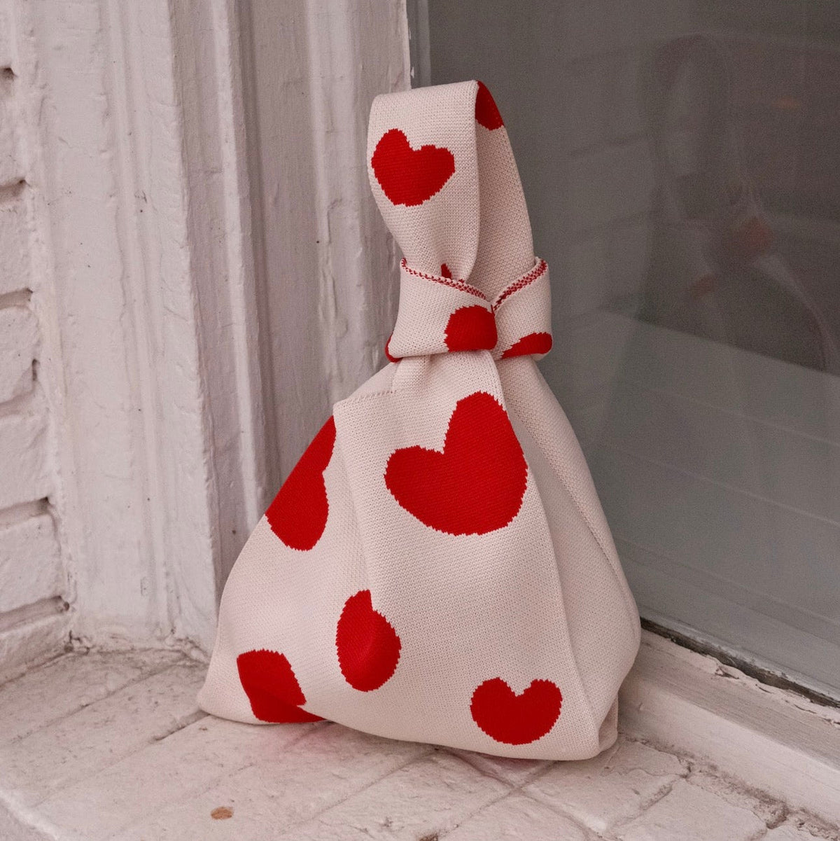 Cream heart-print drawstring handbag, full view with gathered top