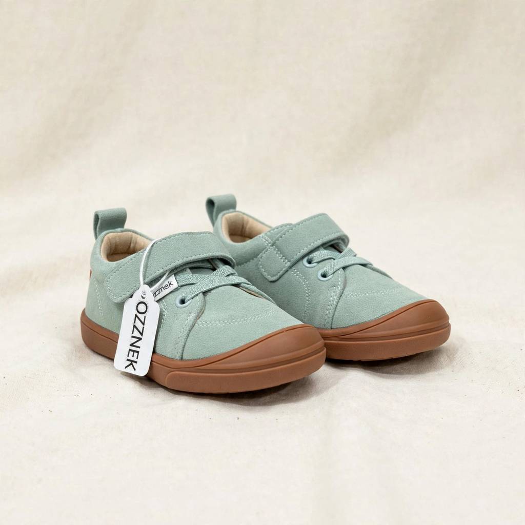 Pair of kids’ light green barefoot sneakers with brown gum-style soles and lace-up front