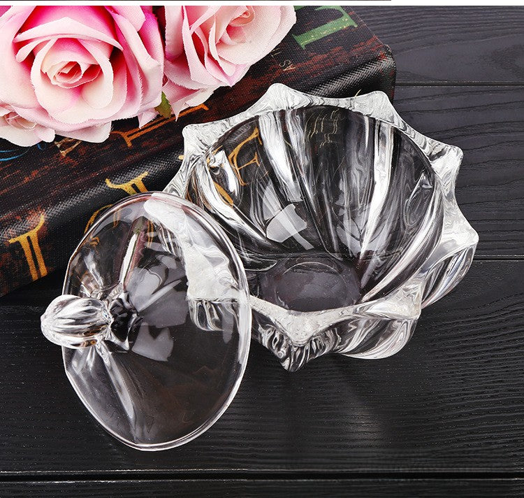 Open, empty cut-glass jar with its rounded lid placed beside it