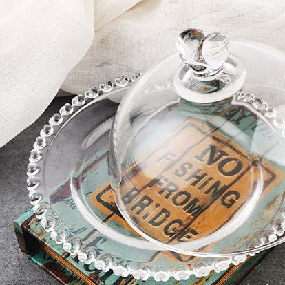 Round glass serving dish and dome shown from above, with decorative beaded rim