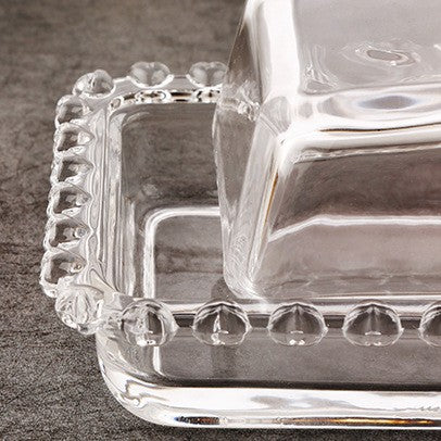 Close-up of rectangular glass dish corner with raised beaded rim and fitted cover