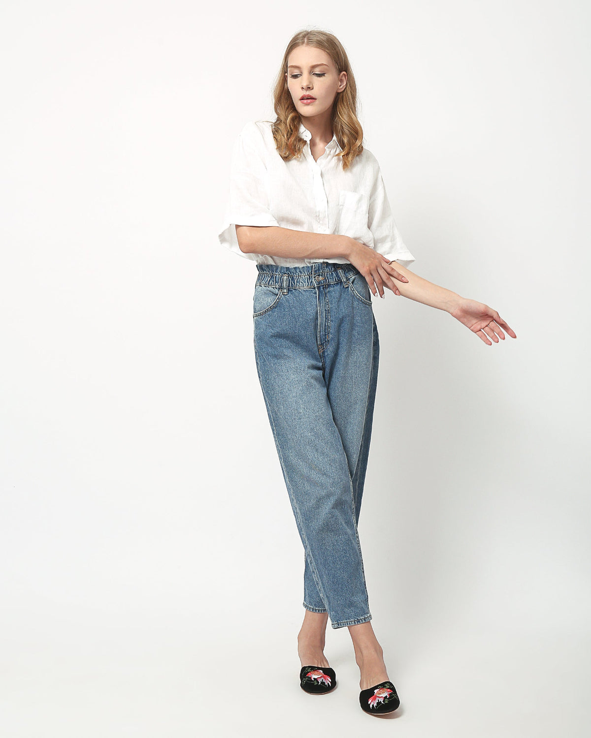 Goldfish-embroidered black velvet mule slippers on a model