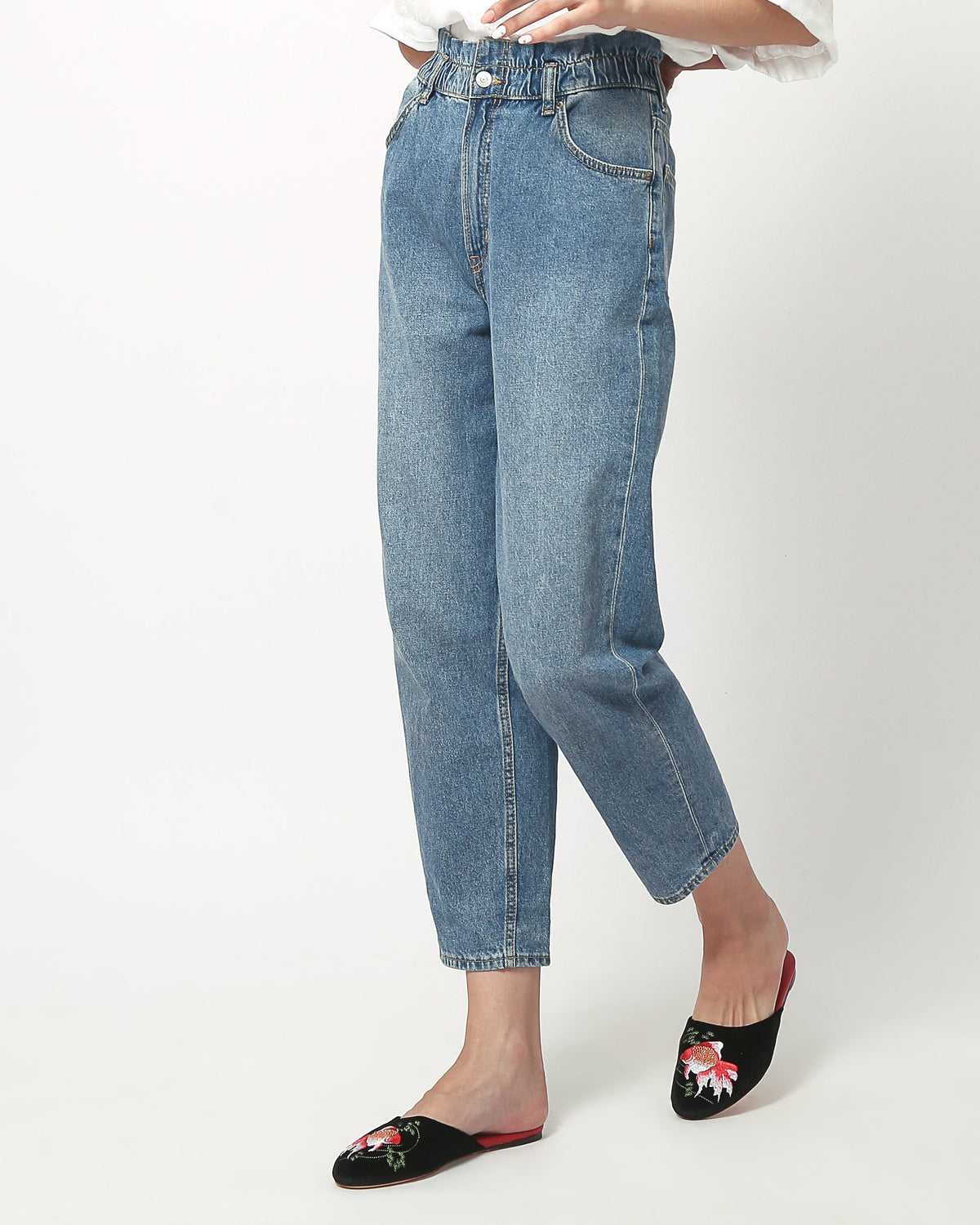 Black velvet mule slippers with goldfish embroidery and red soles on model