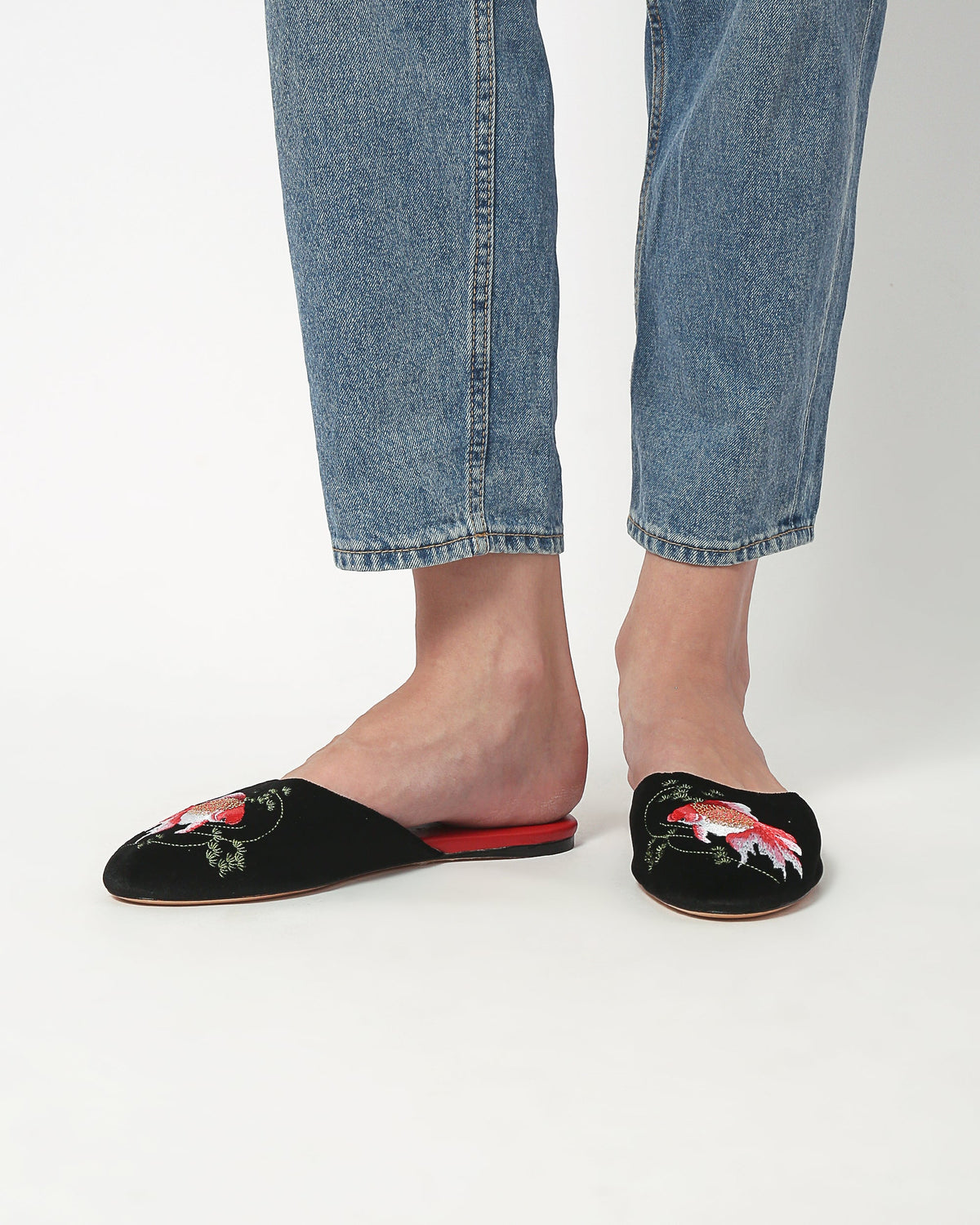 Black velvet mule slippers with goldfish embroidery, cropped at ankles