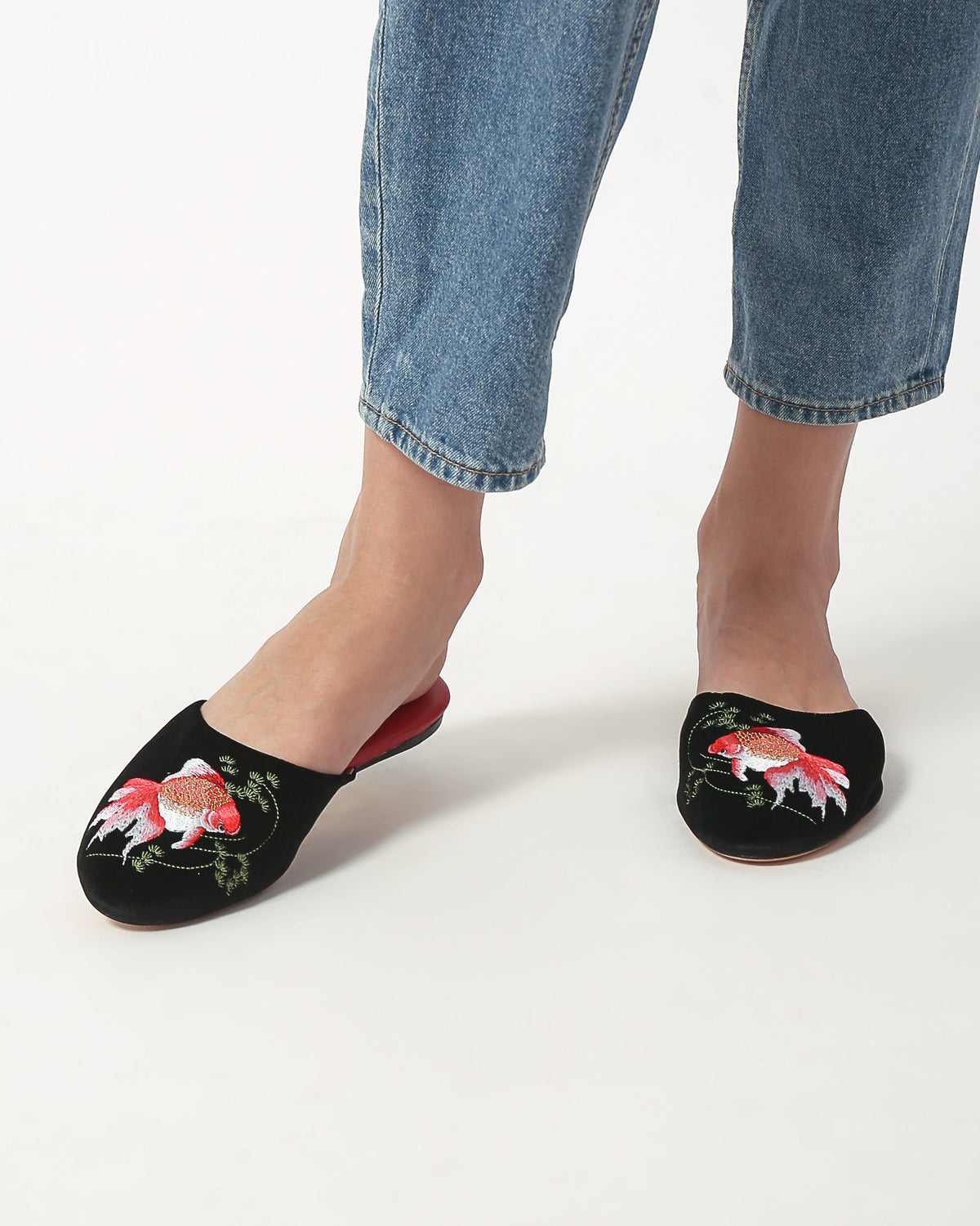 Black velvet mule slippers with goldfish embroidery and red trim, side view