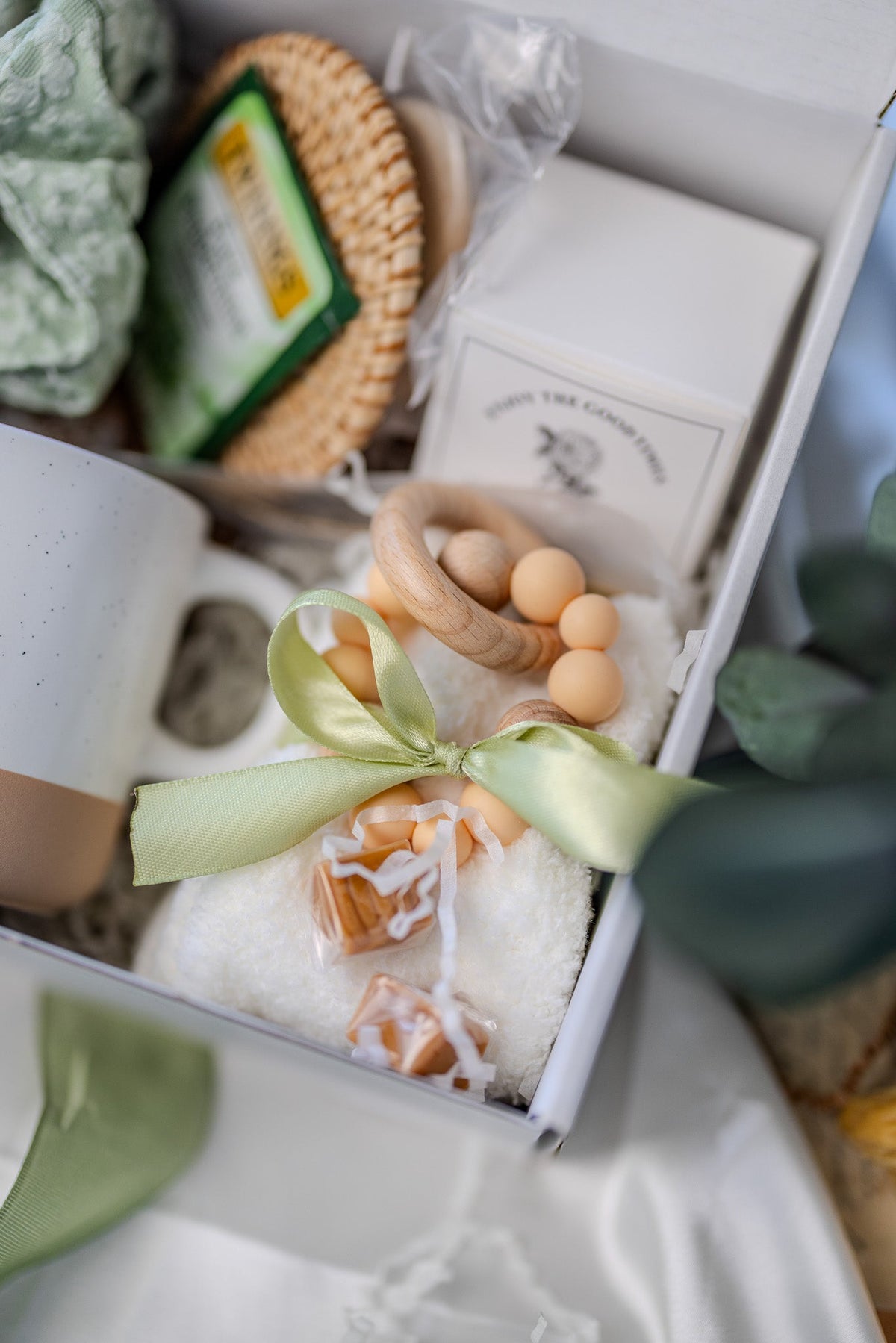 Self-care gift box detail with wooden bead soap, small aroma box, and ribbon bow