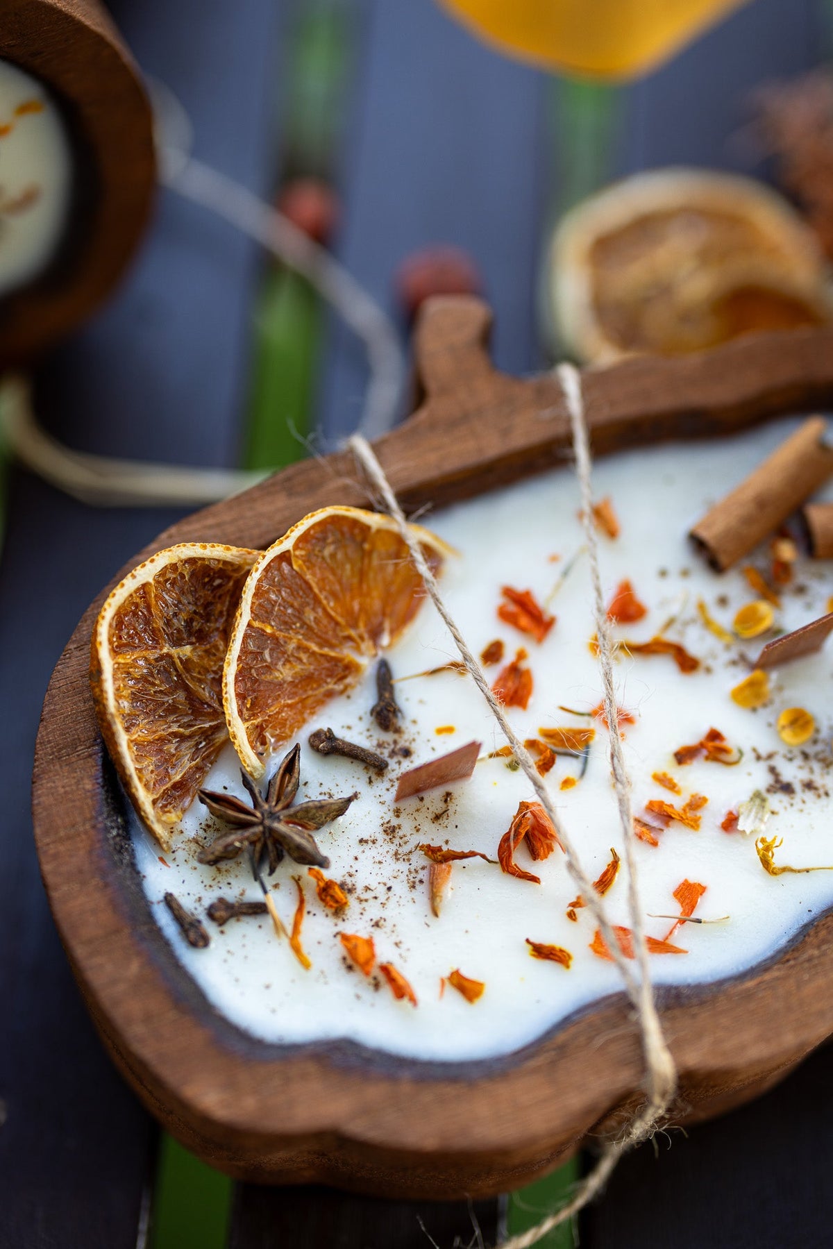 Wooden pumpkin-shaped dough bowl candle with orange slices, star anise, and spice sprinkles