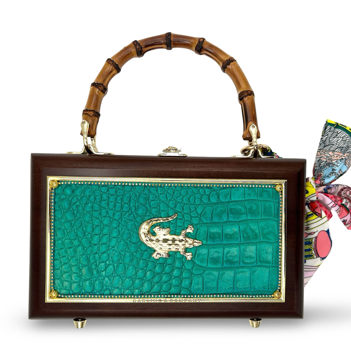 Gator Glam Bag with teal embossed panel, gold emblem, dark wood frame, bamboo handle, and scarf