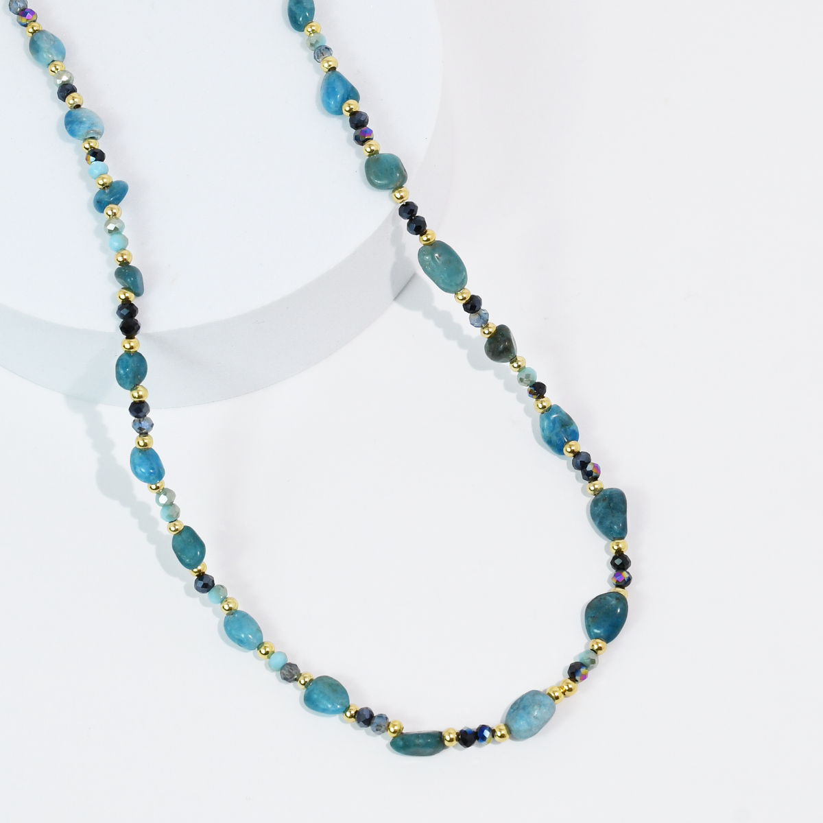 Beaded blue gemstone-style necklace with oval beads, black spacers, and gold-tone accents.
