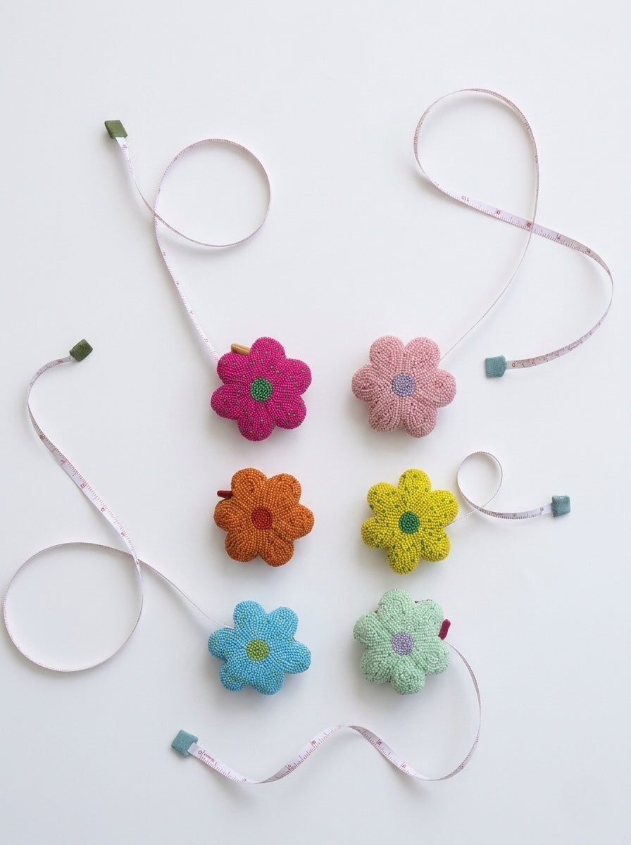 Glass beaded flower tape measure with multicolor flower heads and white ribbon tape