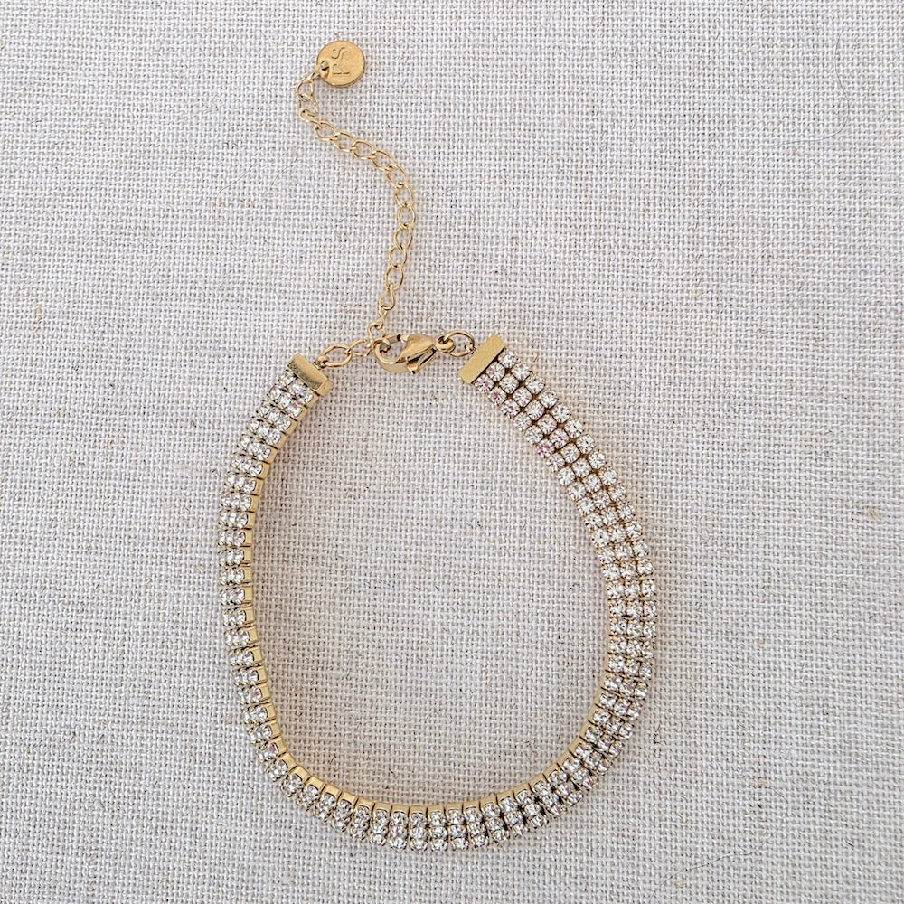 Gold layered tennis bracelet with sparkling rhinestone oval loop