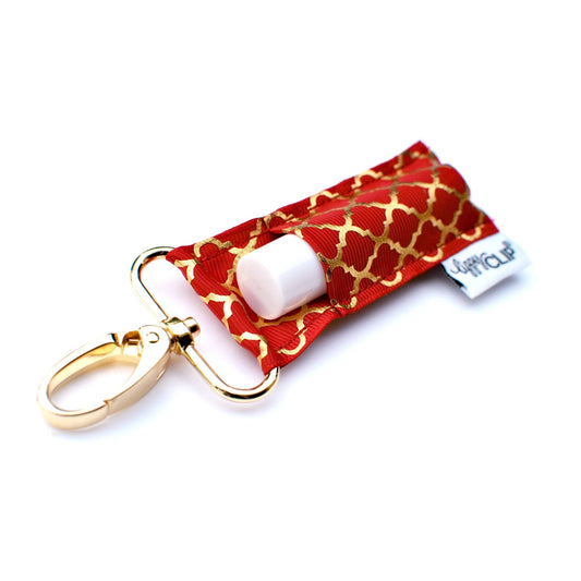 Cranberry red quatrefoil lip balm holder with gold keychain clip and white balm tube