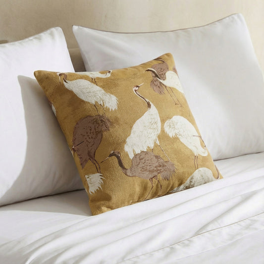 Gold crane throw pillow on white bedding with white, brown, and cream birds
