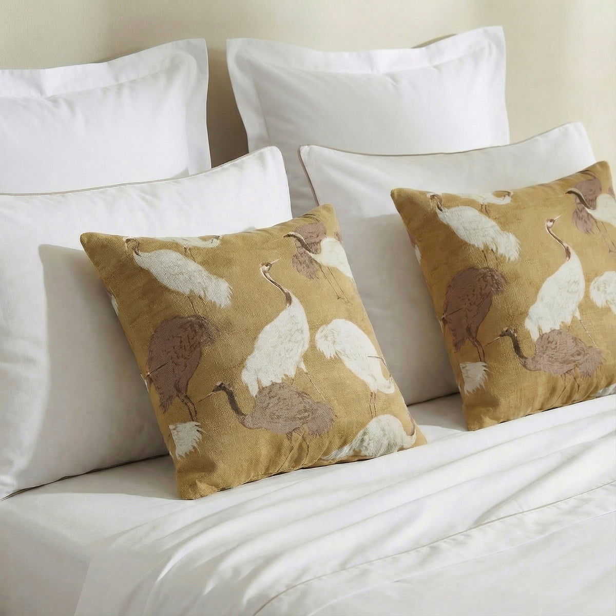 Gold pillows with white and brown crane pattern on bed