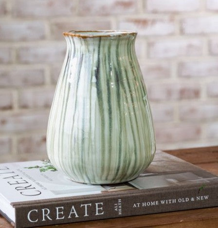 Ceramic vase with vertical light-green stripes and speckled glaze, flared rim