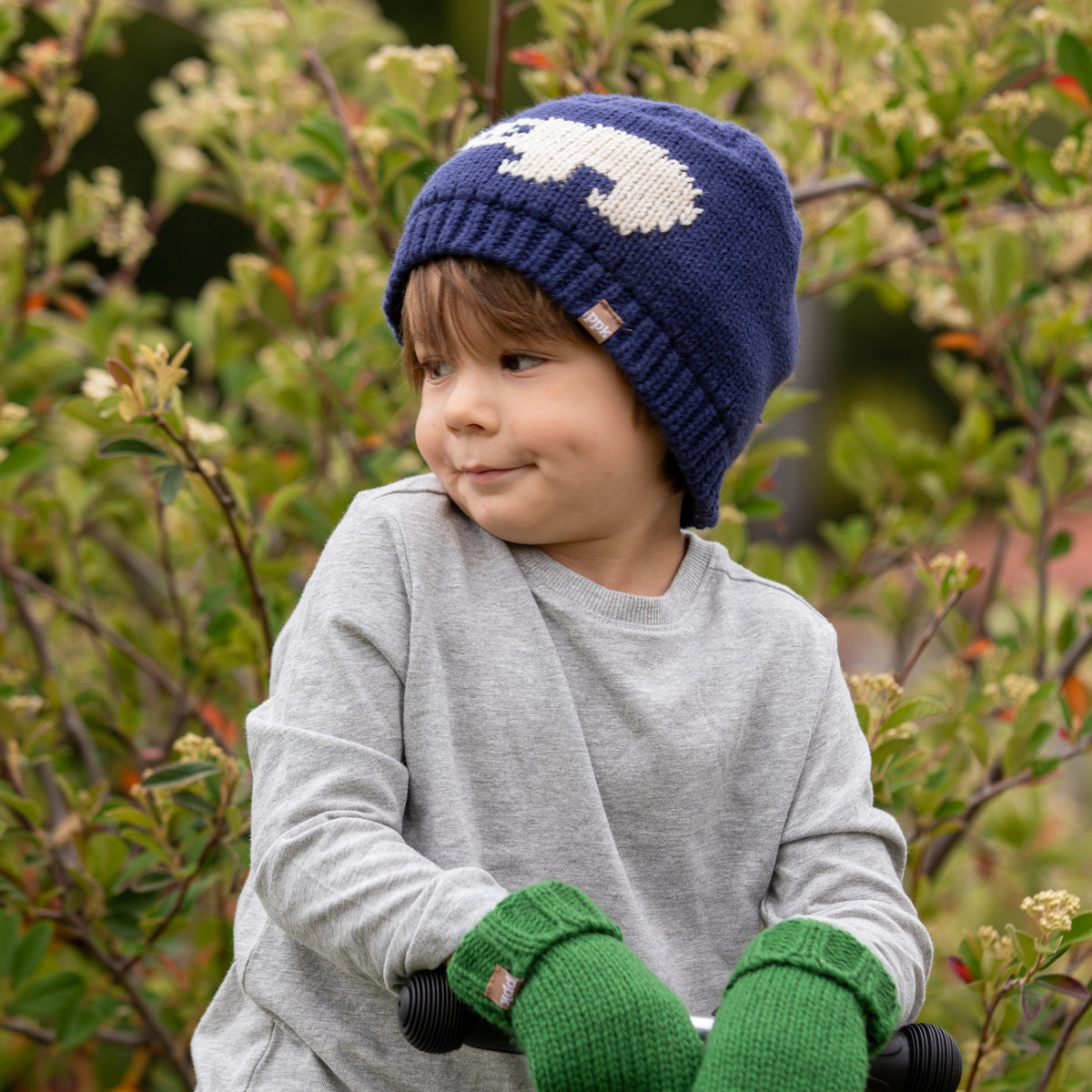Child wearing a navy knit beanie with a white bear motif