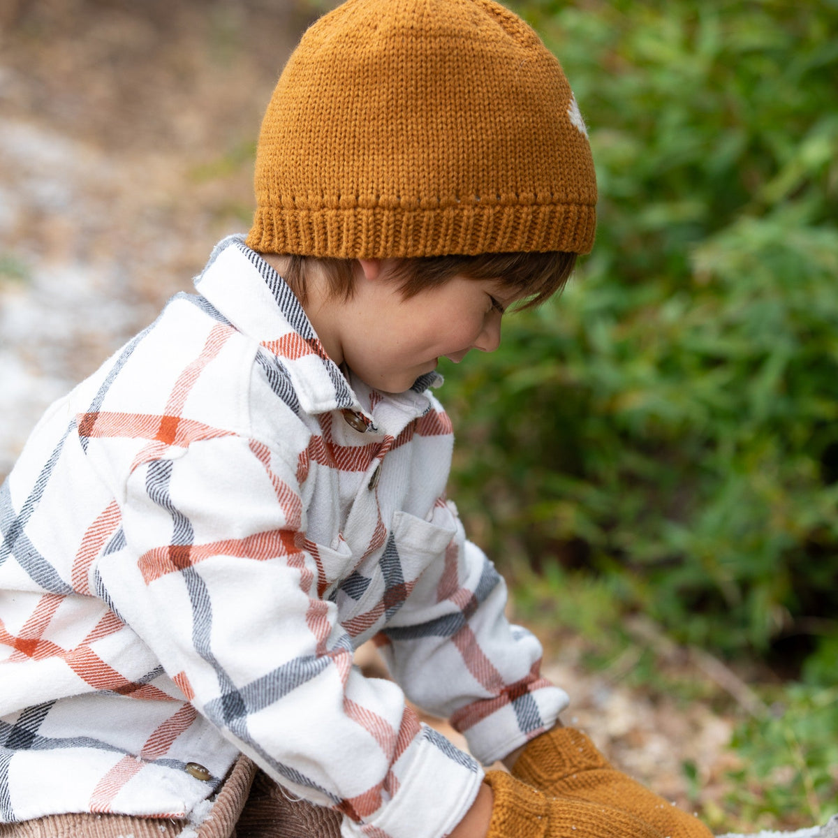 Child wearing a tan knit beanie with a ribbed cuff