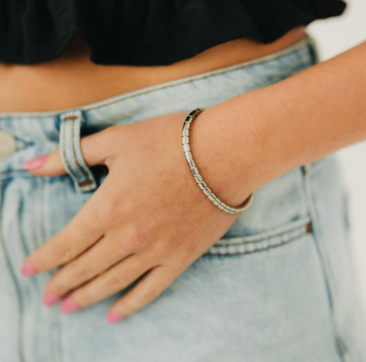 Hinged bangle bracelet with segmented metal links, worn on wrist