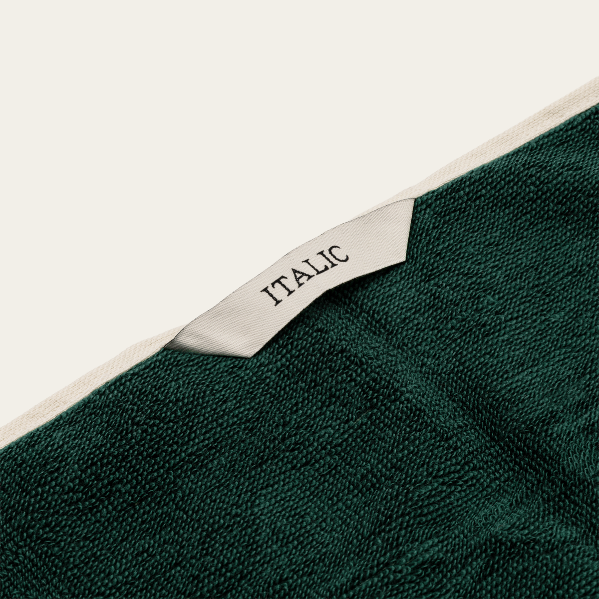 Dark green cotton towel edge with white stripe border and stitched label