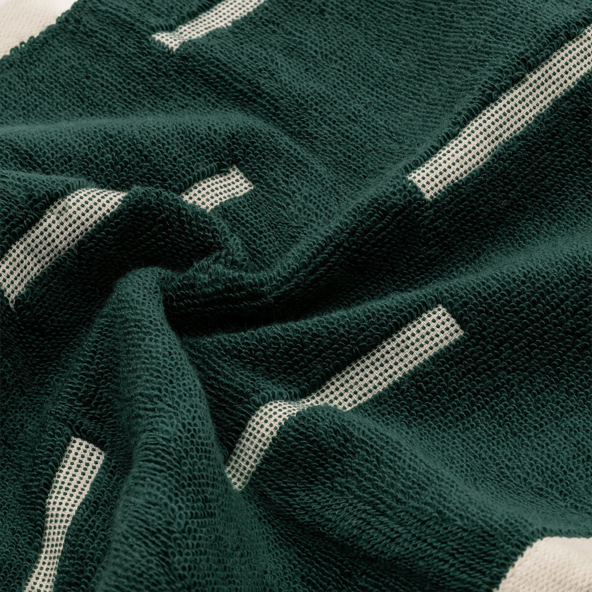 Dark green cotton towel with textured weave and ecru stripe pattern