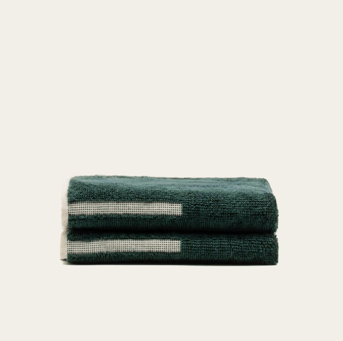 Cotton towel stack in dark green with ecru stripe details, folded