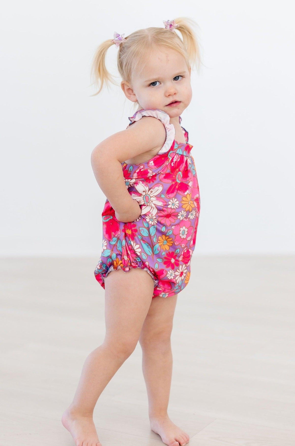 Pink floral romper with V-neck ruffled straps and elastic leg openings