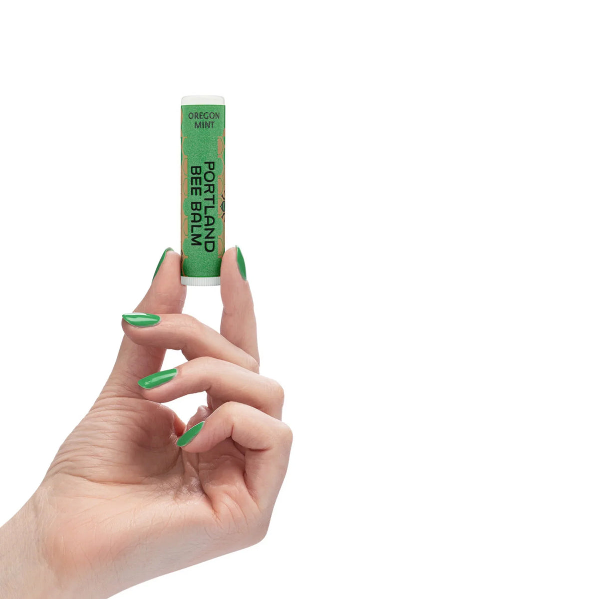 Green Oregon mint lip balm tube held in a hand with mint-colored nails