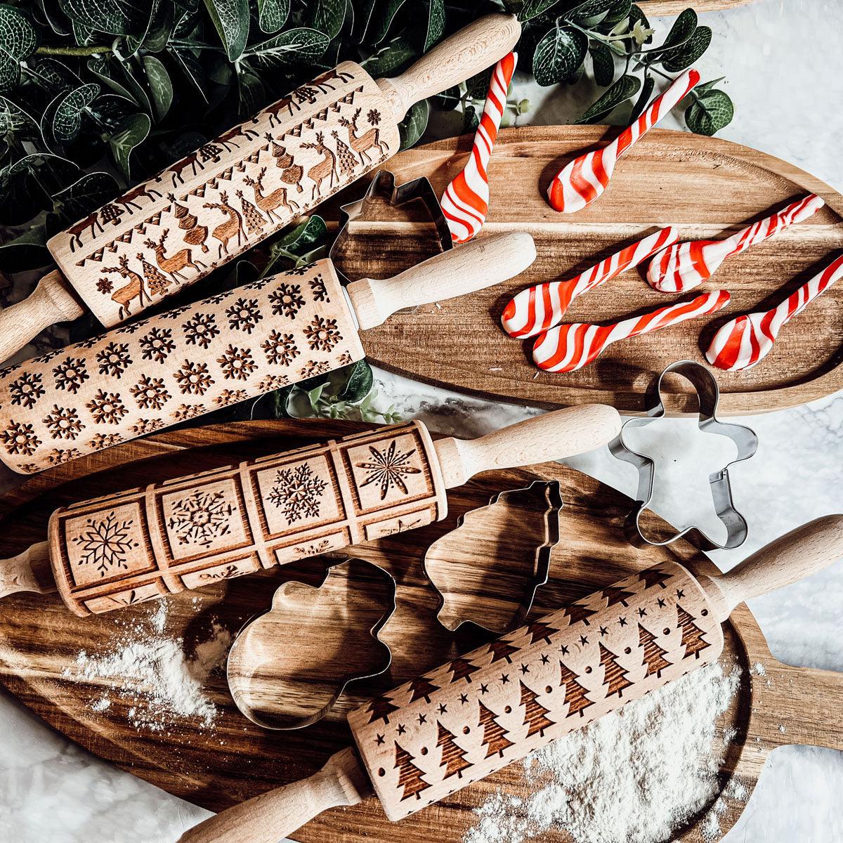 Wooden rolling pins with brown holiday designs and flour on the baking surface