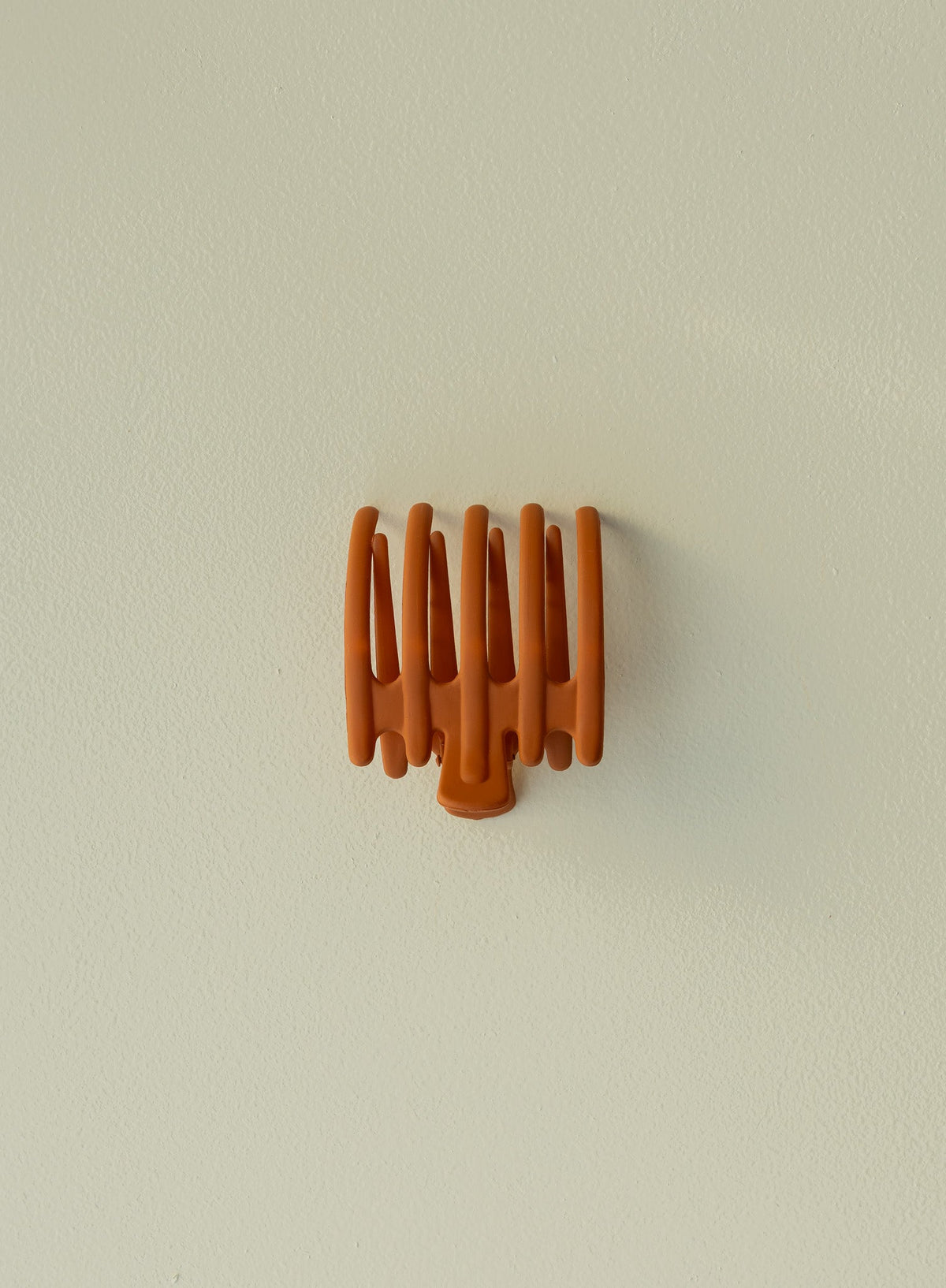 Wide hair claw clip in burnt orange, shown without hair