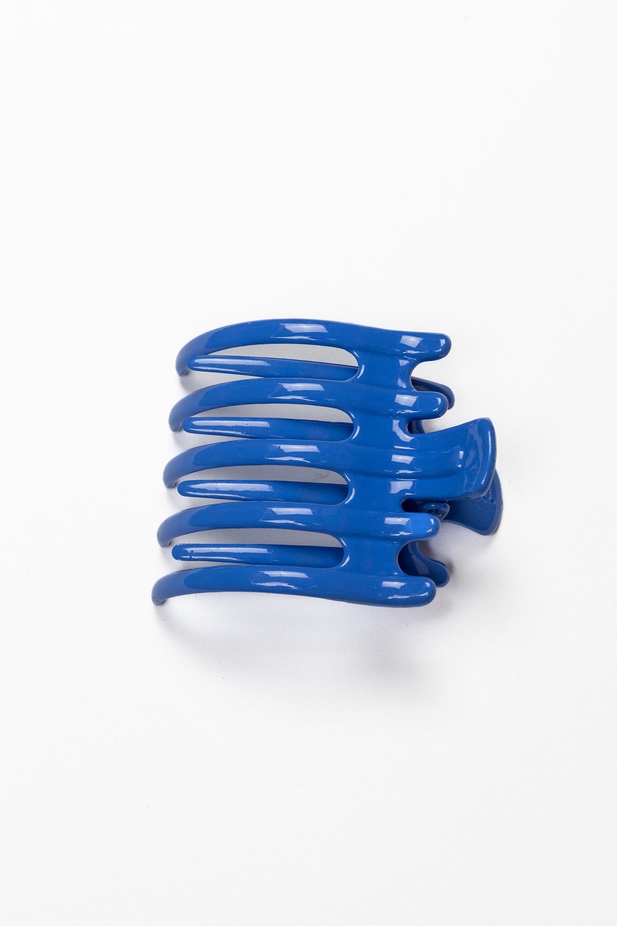 Wide lay-down claw hair clip, glossy royal blue with wide curved grip.