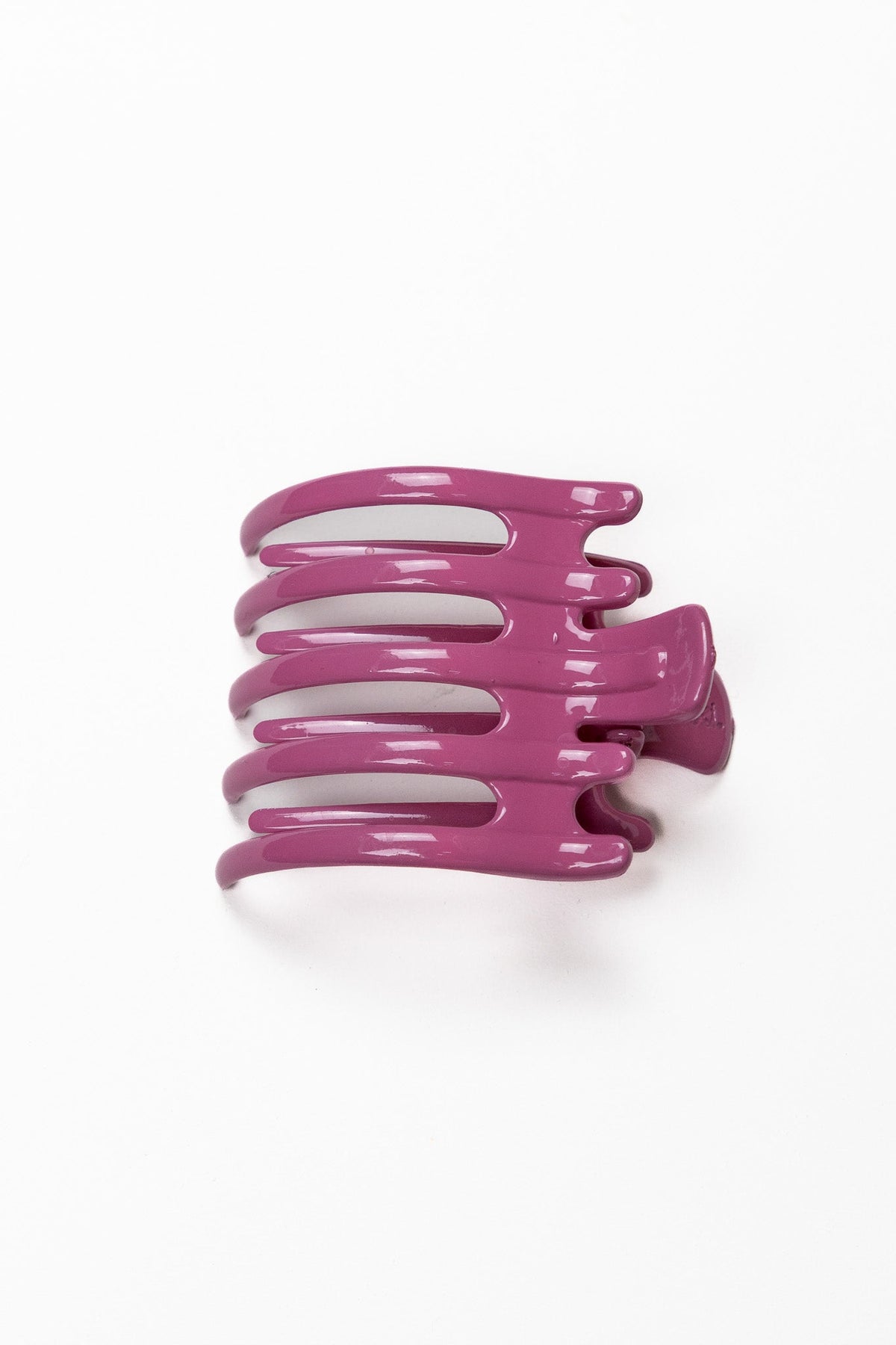 Wide lay-down hair claw, shiny plum-pink color with three curved ridges