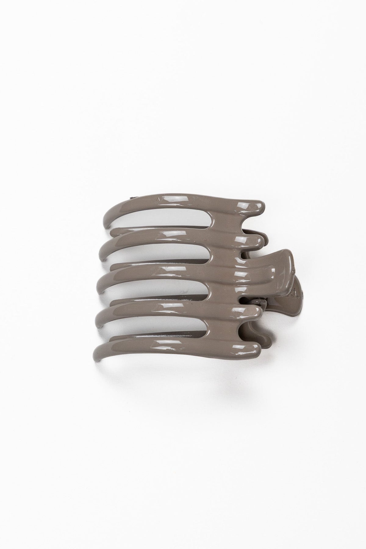 Wide lay down hair claw in shiny taupe, with multiple curved teeth.