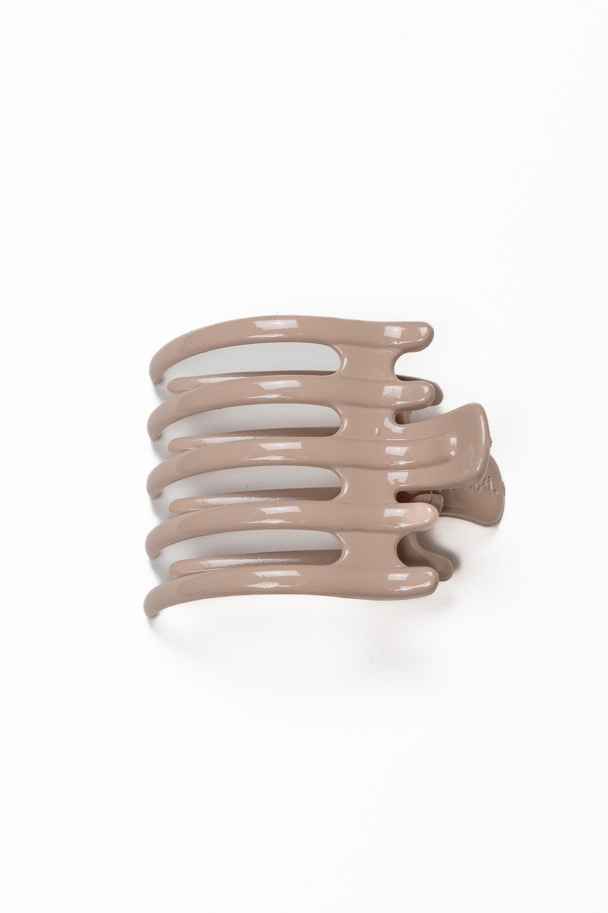 Wide lay down hair claw in shiny light taupe, with multiple curved teeth.