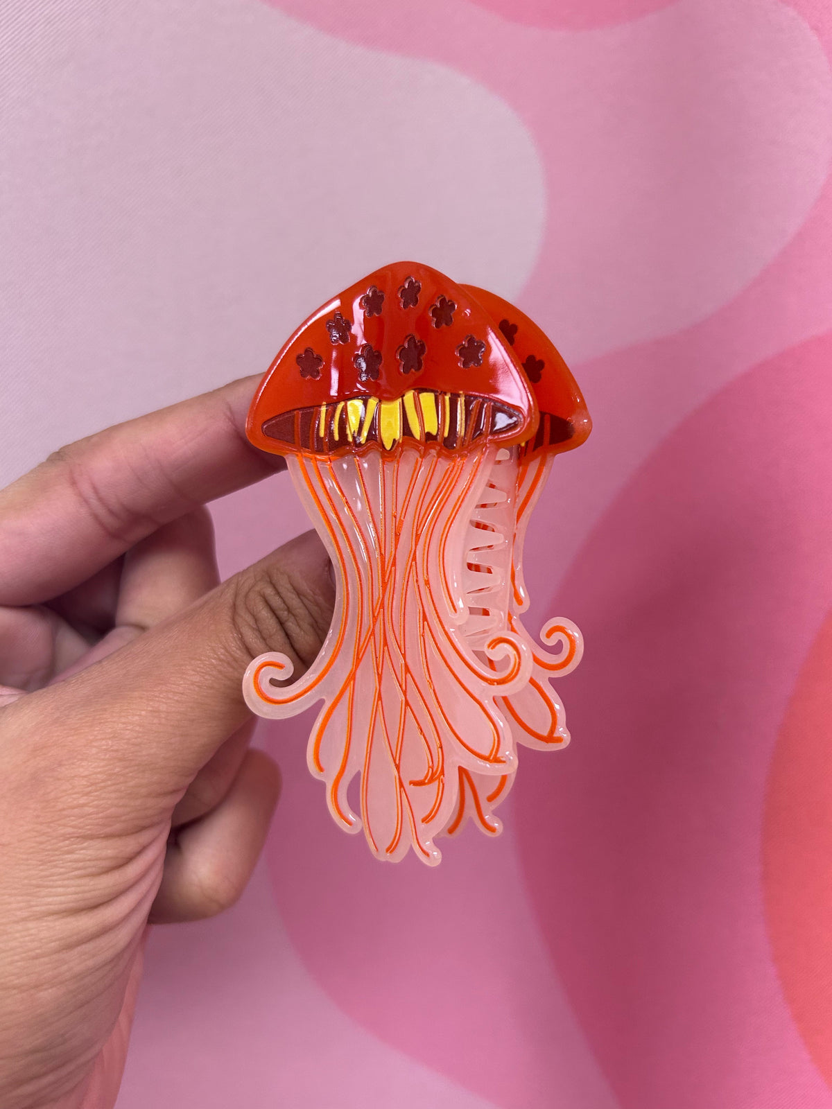 Orange jellyfish hair claw with translucent tentacles and comb teeth