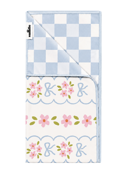 Quick-dry towel with blue check top and floral print bottom, scalloped trim
