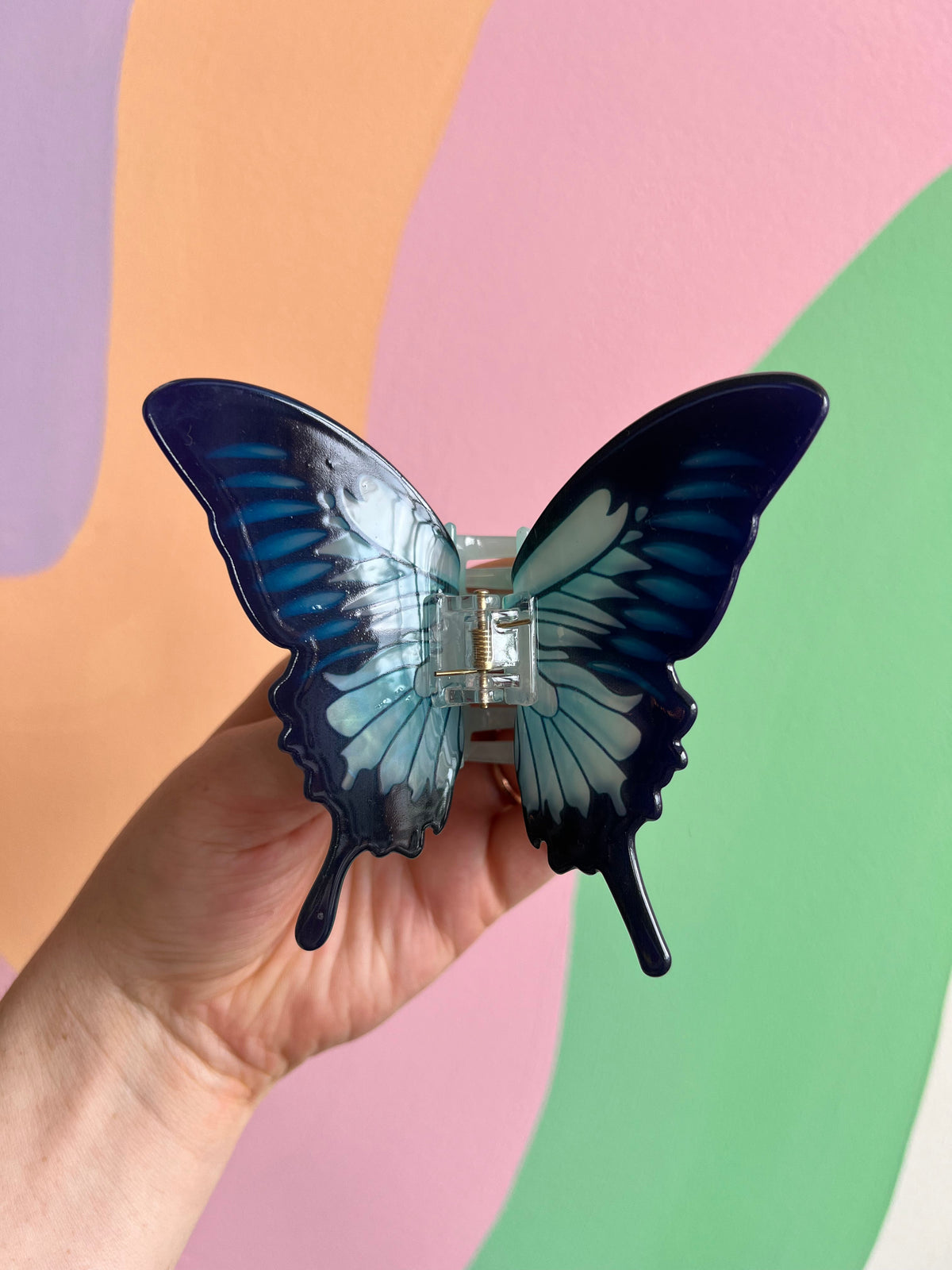Dark blue butterfly hair claw with silver wing veins and central metal clasp