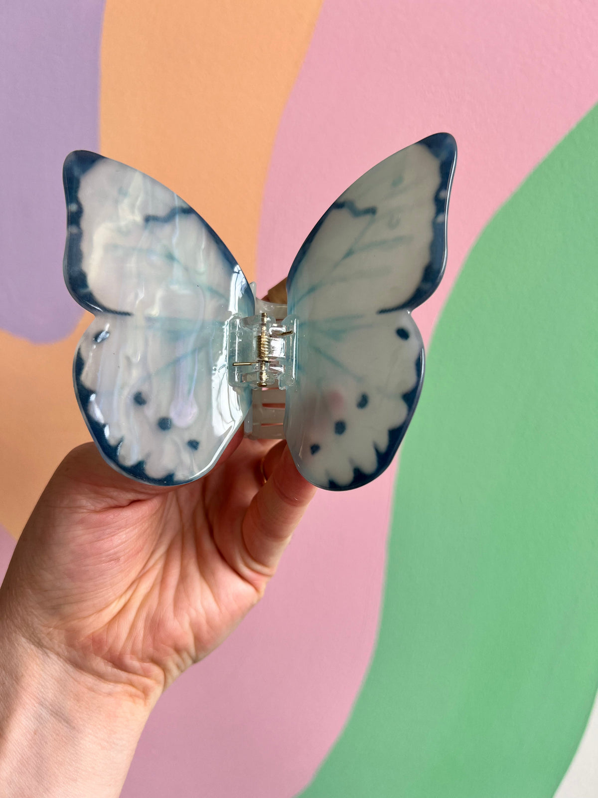 Blue butterfly hair claw with white spots and a clear central clasp
