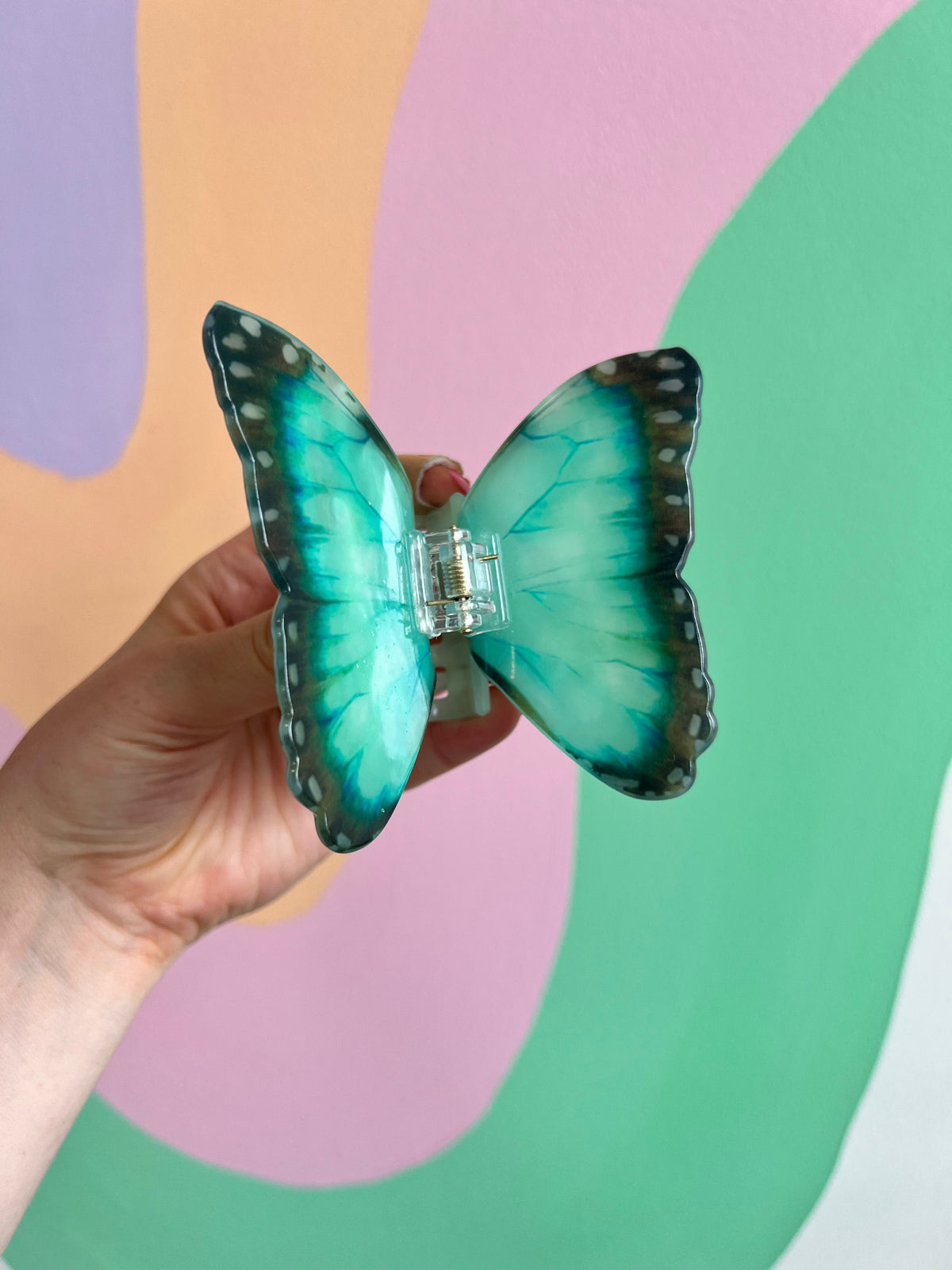Turquoise butterfly hair claw with gold center and detailed dark-edged wings