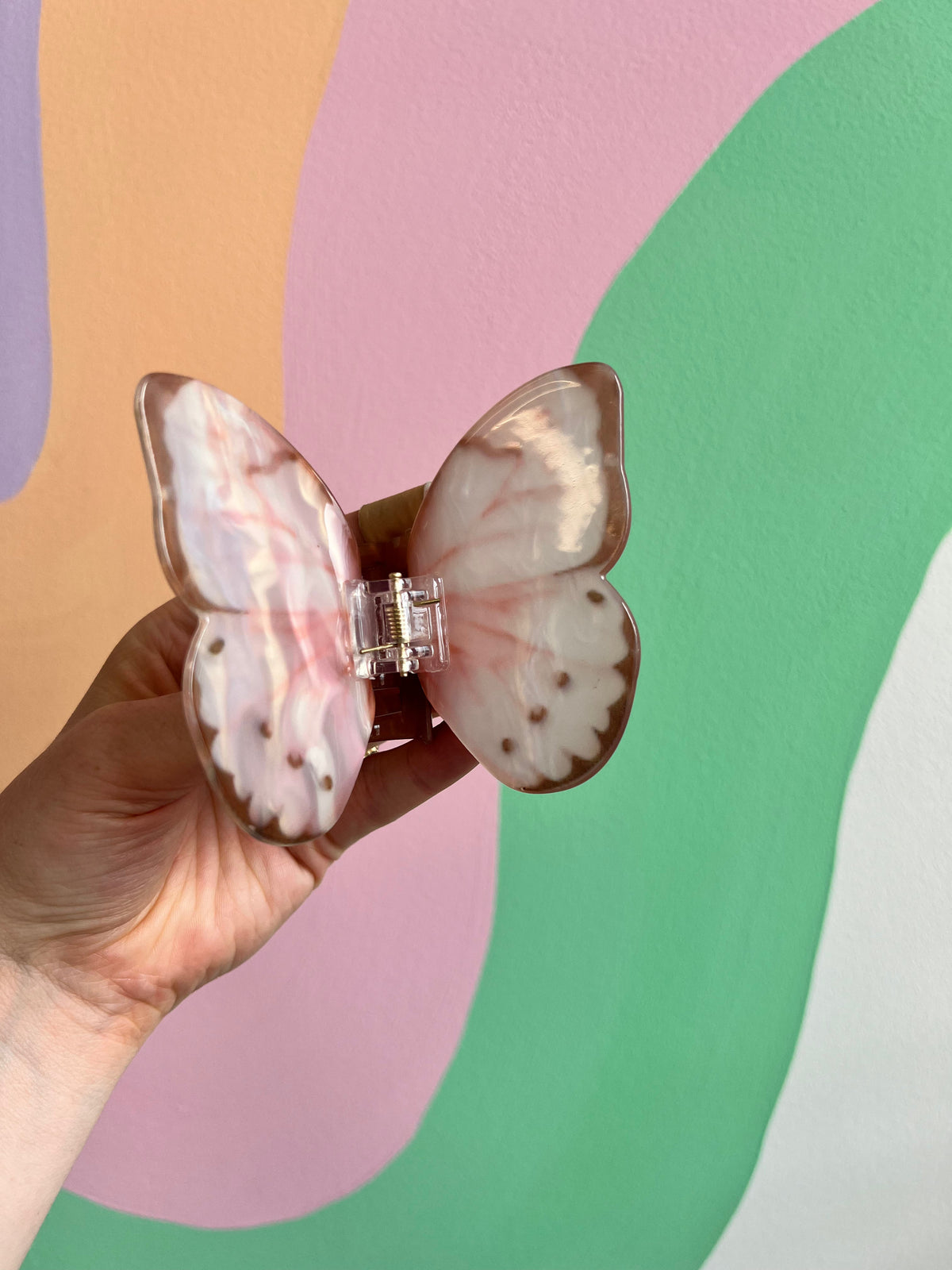 Butterfly hair claw with pink-and-white wings and clear center clasp
