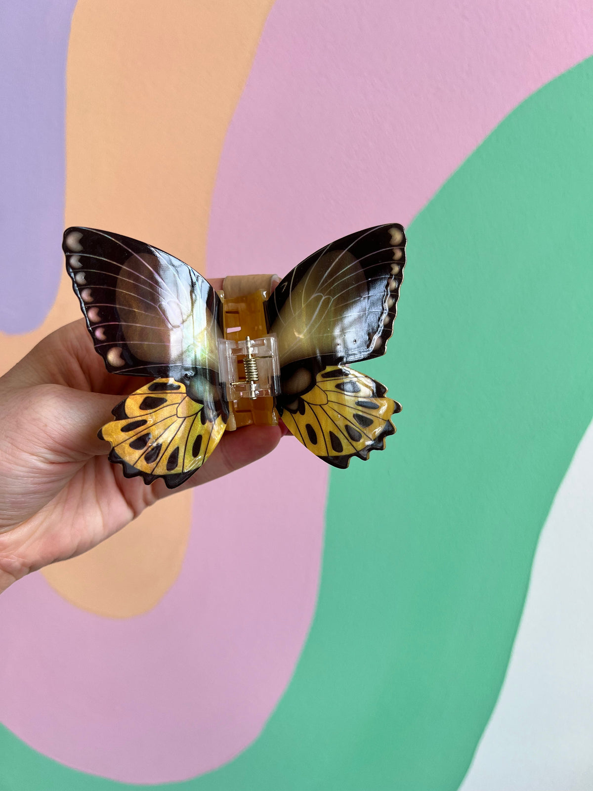 Colorful butterfly hair claw with gold center and blue-and-black wings